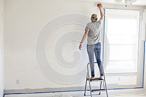 Woman re-painting the interior of her home. Lots of copy space