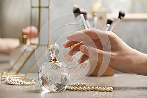 Woman reaching for crystal bottle of luxurious perfume