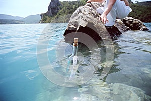 Woman reaching for a message in a bottle