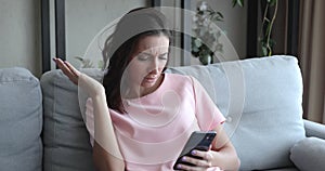 Woman read message on smartphone feels upset by bad news