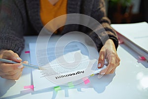 woman reading agreement document in office