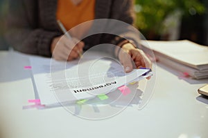 woman reading agreement document in office