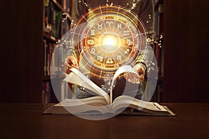 Woman reading a astrology book. Astrological wheel projection, choose a zodiac sign. Trust horoscope future predictions,