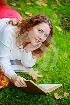 Woman reading a book in the autumn park