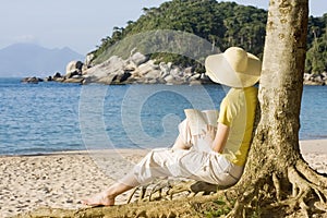 Una donna lettura un libro sul Spiaggia 