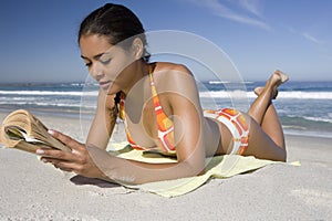 Woman While Reading Book At Beach