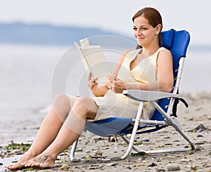 Woman reading book at beach