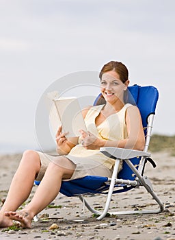 Woman reading book at beach