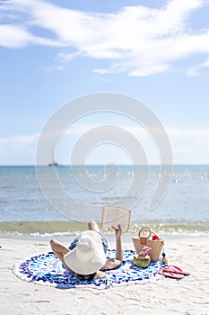 Woman is reading a book on beach