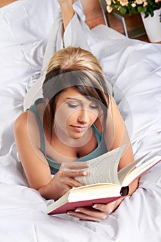 Woman reading book on bed