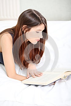 Woman reading a book on the bed