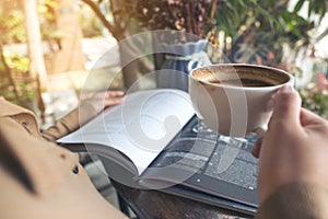 A woman reading book and drinking coffee in cafe