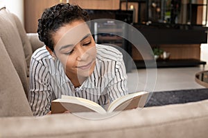Woman reading book and enjoying weekend in the sofa