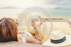 Woman reading a book on hammock beach in free time summer holiday