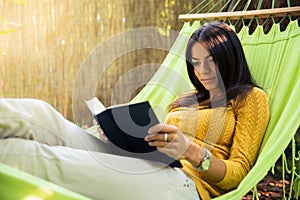 Woman reading book on hammok