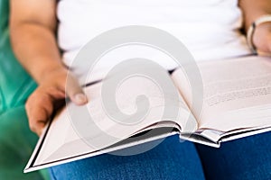 Woman is reading a book on her lap