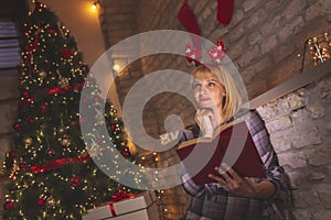 Woman reading a book at home for Christmas Eve