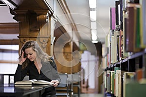 Woman reading book in old library