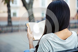 Woman reading book outdoors