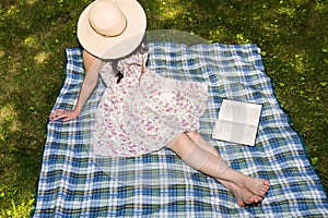 Woman reading a book outside in the grass