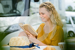 Woman reading book outsider camper