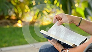 Woman reading book in a park