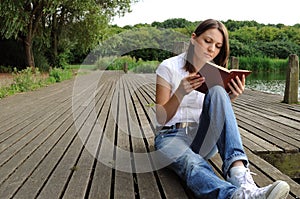 Woman reading book by river