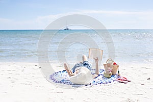 Woman is reading a book on beach
