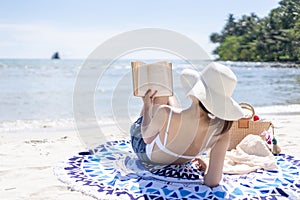 Woman is reading a book on beach