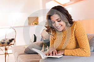 Woman reading book on sofa