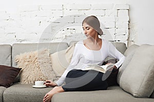 Woman reading a book on sofa