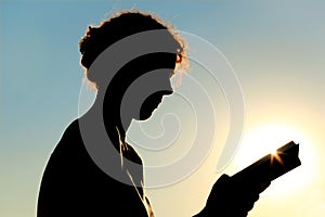 Woman reading book, sunlight