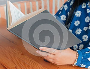 woman reading book at table