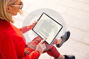 Woman reading a book on tablet