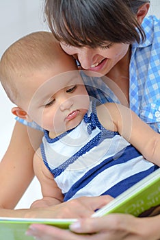 woman reading book to baby photo