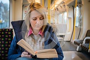 Woman reading book in a train