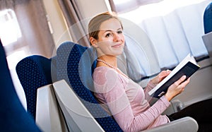 Woman reading a book while on a train