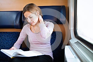 Woman reading a book while on a train