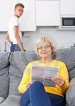 Woman reading booklet on sofa
