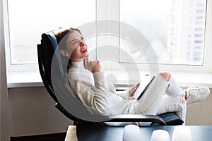Woman reading e-book by the window