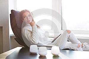 Woman reading e-book by the window