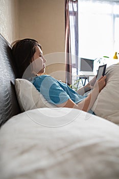 woman reading electronic book in bed.