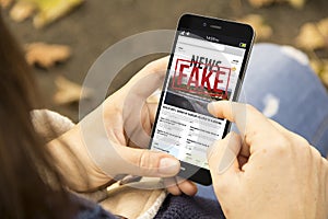 woman reading fake news in the park photo