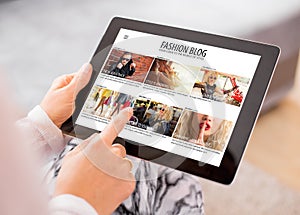 Woman reading fashion blog on tablet photo