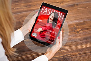 Woman reading fashion magazine on tablet photo