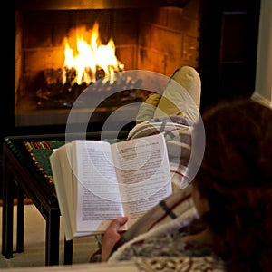 Woman reading by fireplace