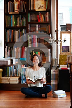 Woman, reading and floor in bookstore, portrait or relax with development for knowledge, information and literature