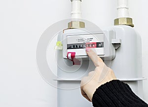 Woman reading the gas meter in the private house, counter for distribution domestic gas