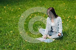 Woman reading on grass in park