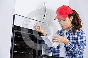 Woman reading instructions for new oven